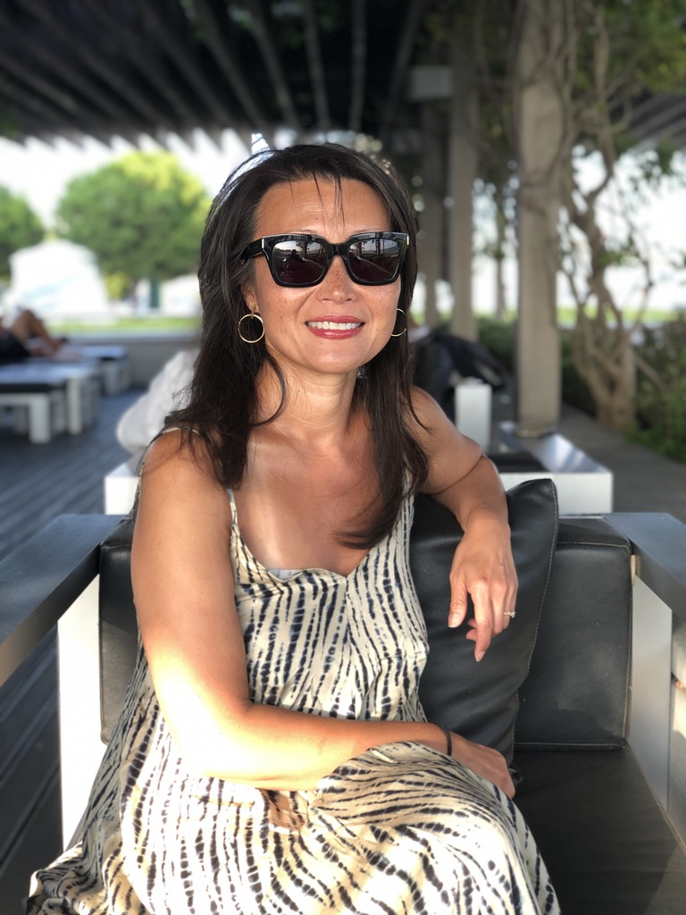 Bo, YEOYU travel advisor, seated in a shaded outdoor lounge